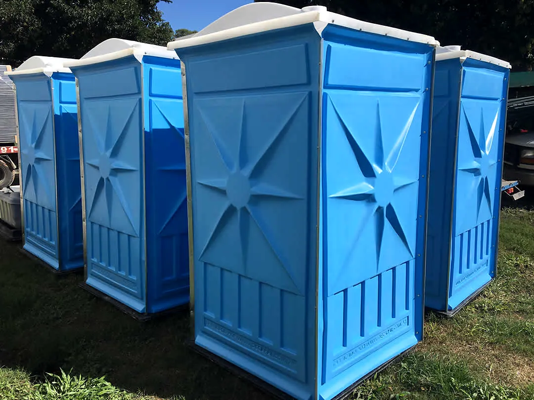 Fila de baños químicos azules en exterior