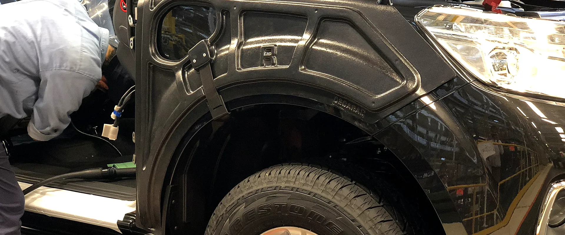 Cubre guardabarro plástico Decaral instalado en una camioneta en la línea de montaje