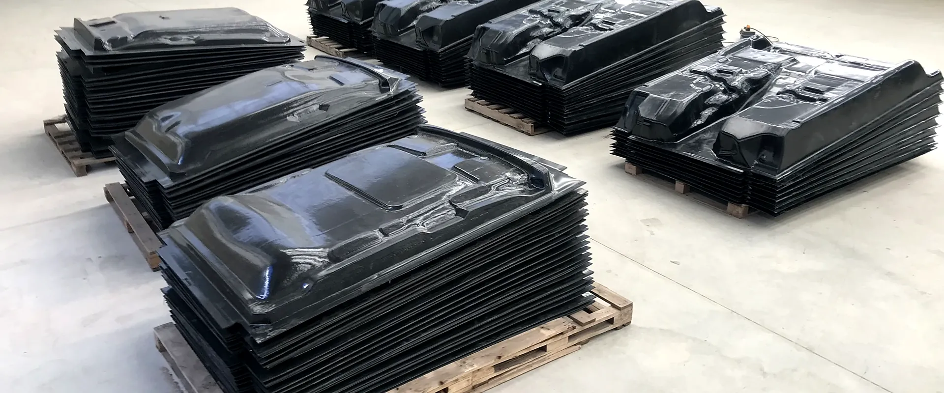 Pallets con porta alfombras termoformados apilados en la planta