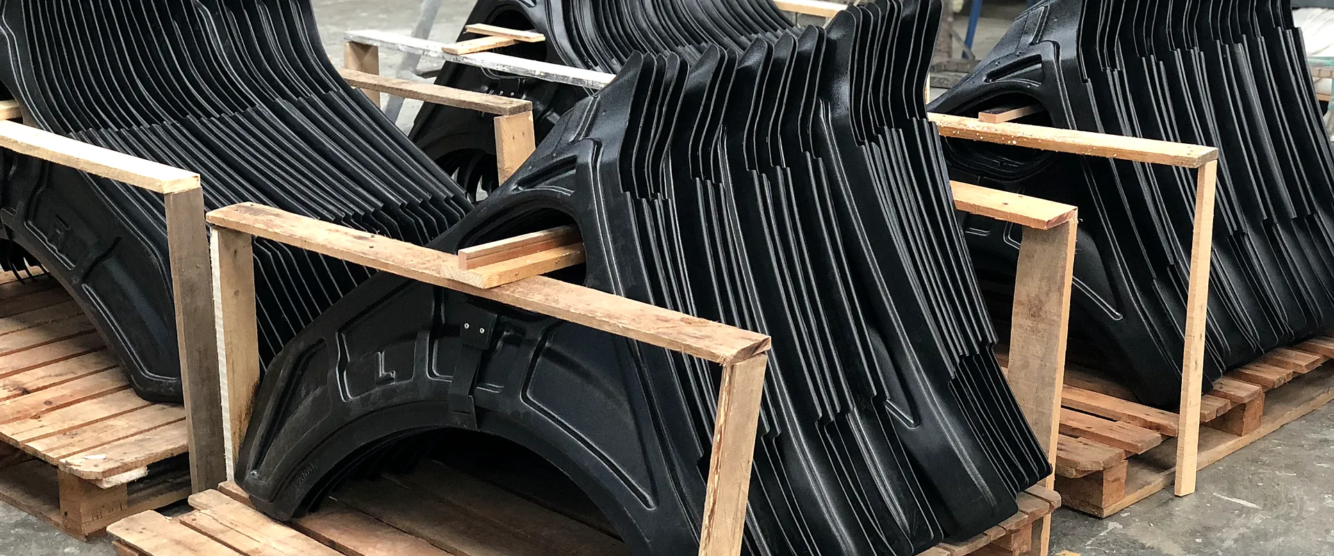 Cubre guardabarros termoformados apilados en soportes de madera